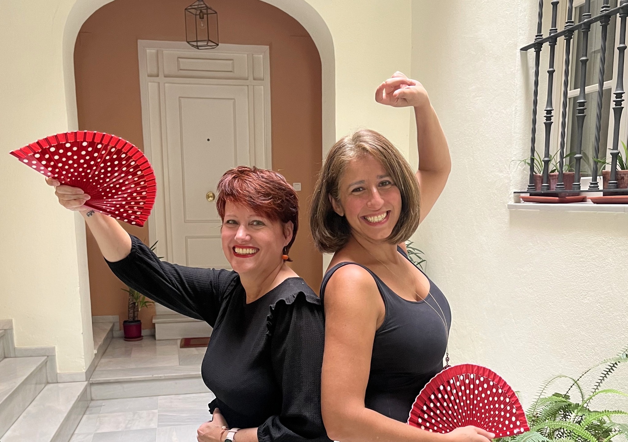 Randa and Adrienne posing playfully with red flamenco fans