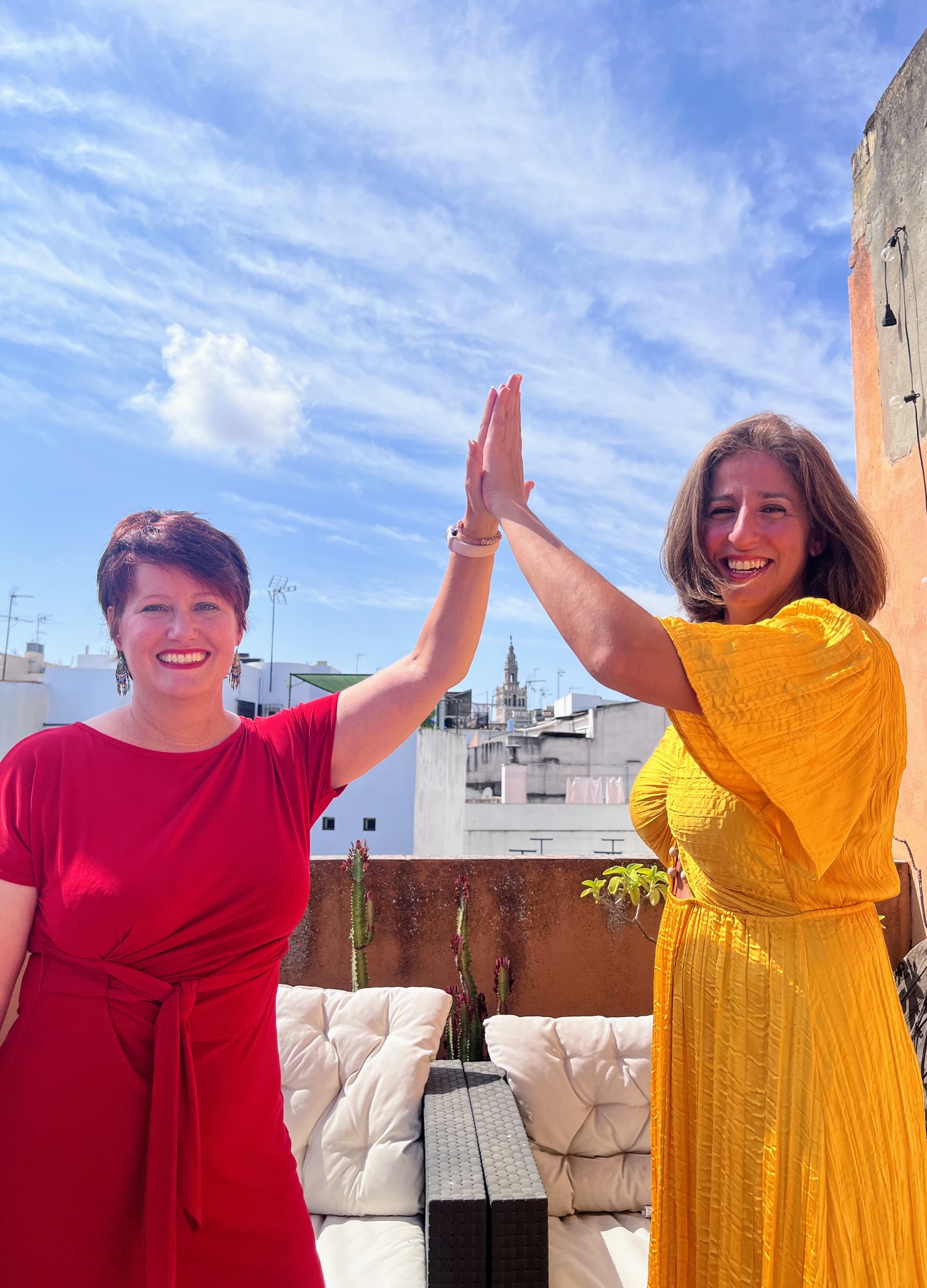 Randa and Adrienne together in red and gold on a Sevilla rooftop